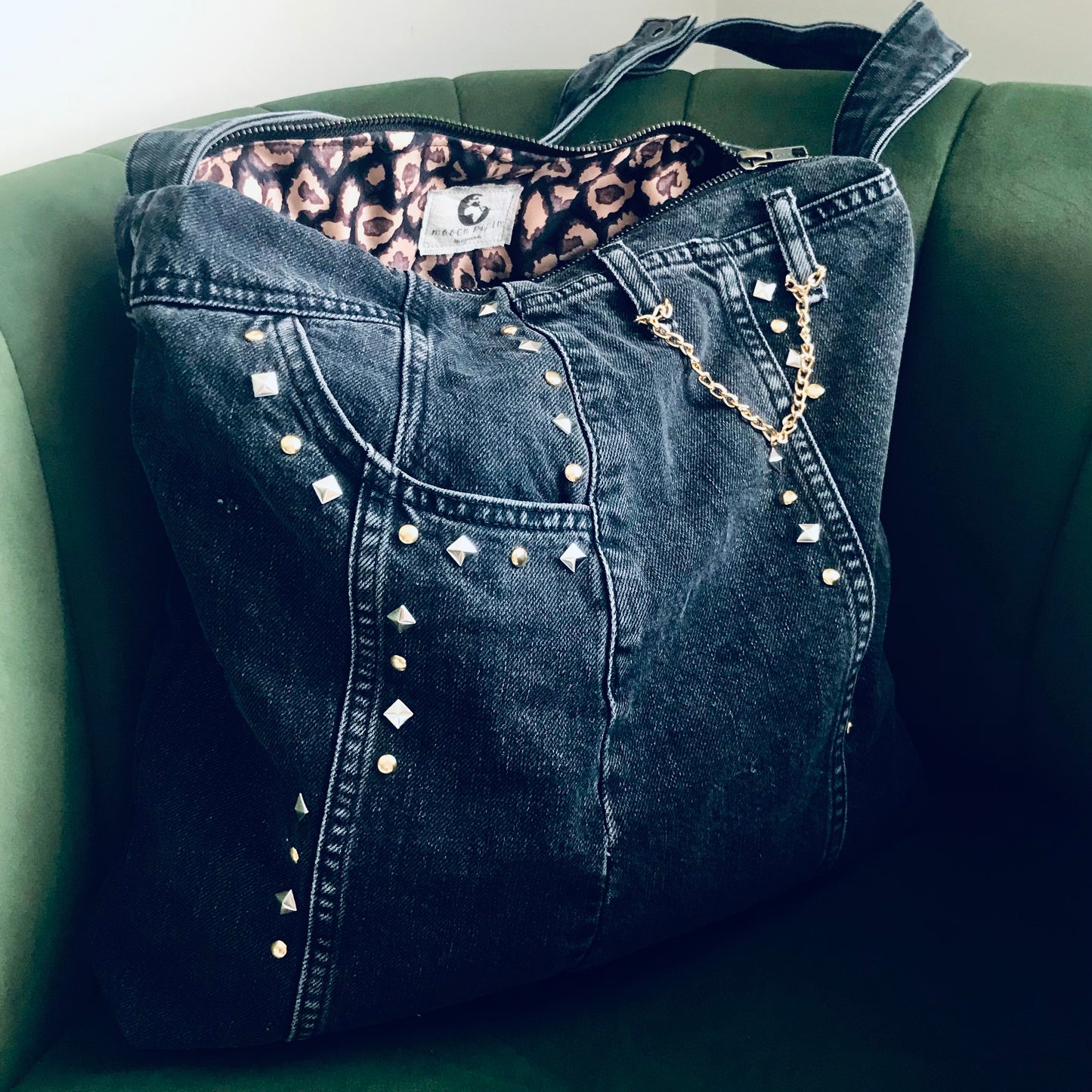 Black studded shoulder bag with animal print lining and chain